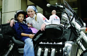 Proof that motorcycles are babe magnets? Supermodel Niki Taylor shows a young fan the finer points of a Rocket III.