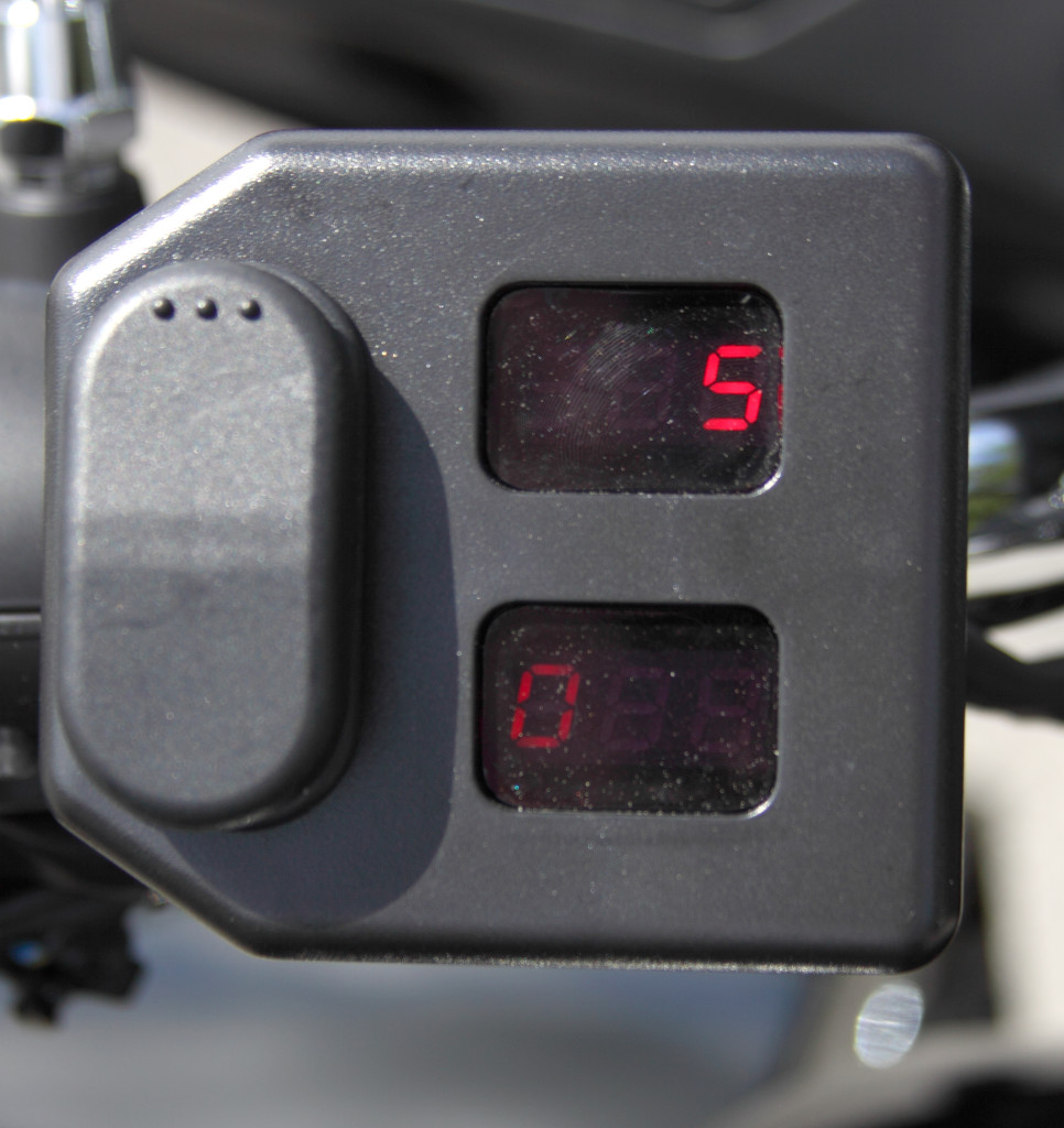 Box on left handlebar adjusts air pressure for rear suspension, and includes a voltmeter.