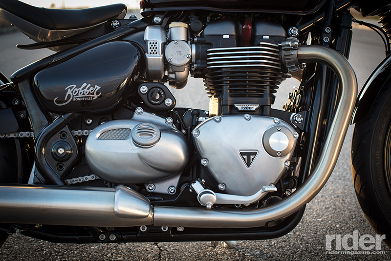 The Bobber's 1200cc "High Torque" engine is the same one as that used in the T120, but for the Bobber it's been tweaked to produce 10 percent more power and torque. Triumph designed it with what they call "Clean Lines" packaging, hiding wires, hoses and any other unsightly bits for a clean, attractive look. For example, the radiator's expansion tank is located under the silver mesh panel on the left in the photo.