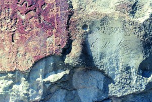 Petroglyphs scratched on El Morro by ancient Puebloans, circa 1300, survive alongside the 1857 signature of pioneer E. Pen Long.