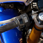 2012 Yamaha YZF-R1: Rocker swtich on the left handlebar sets traction control level. Combined with D-Mode throttle response maps, there are 21 possible combinations.