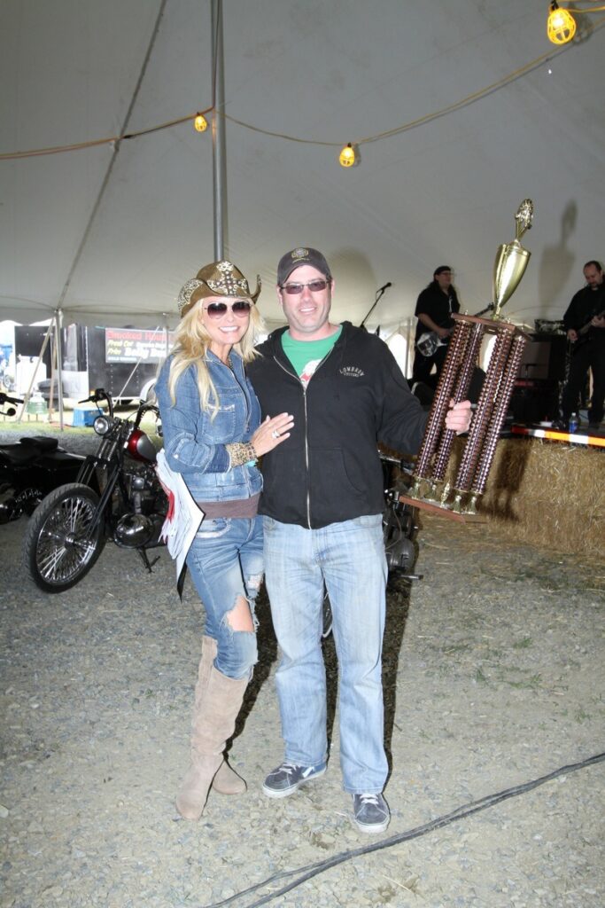 Michele Smith presents bike show winner Ben Fernon with his first-place trophy