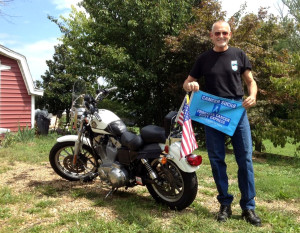 Prostate Cancer Awareness Project founder Robert Hess with his trusty Sportster – and a “Cancer Sucks” flag – at his home in Mt. Sidney in Virginia’s Shenandoah Valley. (Photo courtesy PCAP)