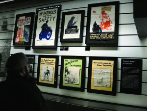 A viewer takes in a wall of posters promoting motorcycle cops as the protector of America’s youth.