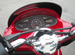 Informative instrument panel is flanked by a chrome handlebar and has a center speedometer, a tripmeter and a fuel gauge.