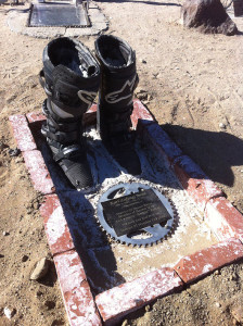 This rider may have died with his boots on, which are set in concrete with a sprocket and a plaque.