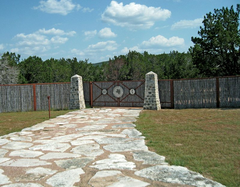 Another fine example of a Texas gate, note the flagstone driveway. I call these Texas gates, but in other parts of the world, a “Texas Gate” is what we call a “cattle guard”—rails set in the ground over a pit to prevent cattle from getting out. They are used instead of gates and can be found on almost any rural Texas Ranch Road.