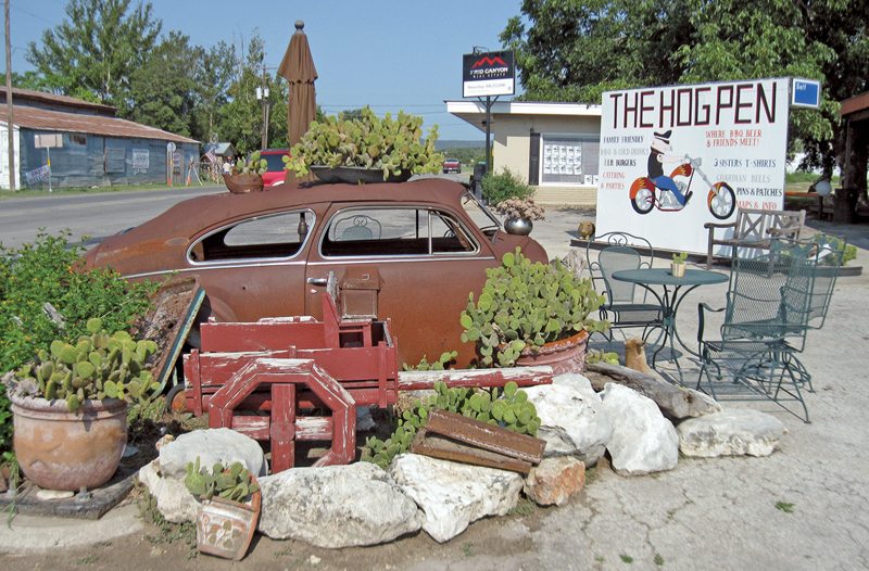 An “art car” decorates the corner of Highway 83 and Ranch Road 337 in downtown Leakey, Texas. The car is at the entrance to The Hog Pen, a motorcycle friendly eatery and store.