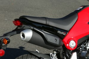 Dirt-bike style seat is hard and includes a passenger grab strap.