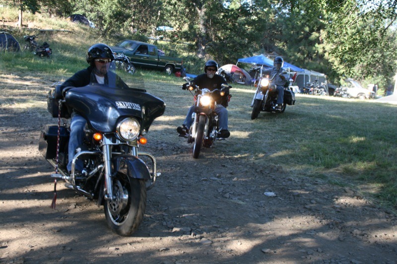 Weary revelers try to successfully maneuver down the bike-dumping gravel road as they head for home