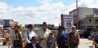 Locals in period costumes welcome visitors to the annual Custer Cruisin' event