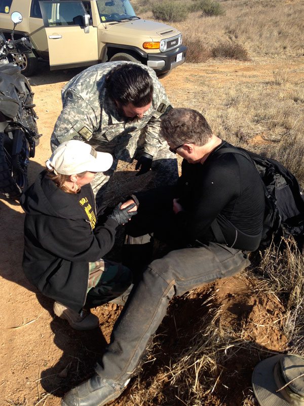 A paramedic and nurse who are members of the Pathfinders militia tend to TJ's injuries.