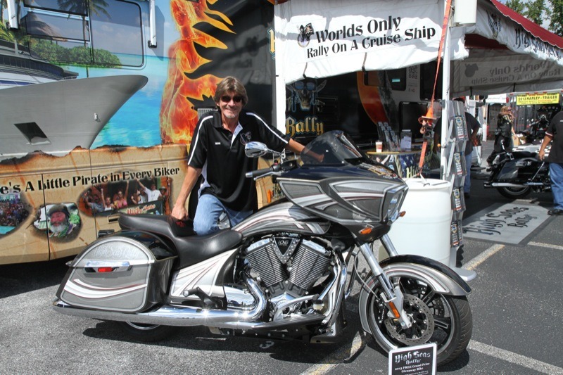 Dean Anderson displays the 2013 Victory Cross Country that will be given away on the High Seas Rally cruise this year