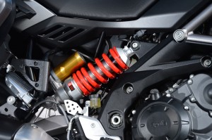 The Caponord's side-mounted rear shock is mounted above the swing arm to protect it from exhaust heat. One of Aprilia's patents on the semi-active suspension system covers its automatic rear preload adjustment mode.