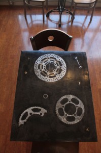Tables embedded with brake rotors, sprockets and other parts add to the industrial-chic look.