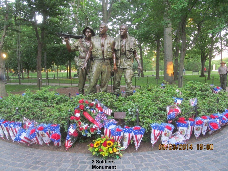 The Three Soldiers statue is littered with bouquets and flags during Rolling Thunder XXVII