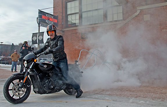 A Harley-Davidson rider removes a brick from the historic front entrance of the company's Milwaukee headquarters using a 2015 Harley-Davidson Street 750 motorcycle.