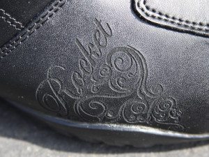 There is artistic detailing on the outer edge of the foot and along the heel.
