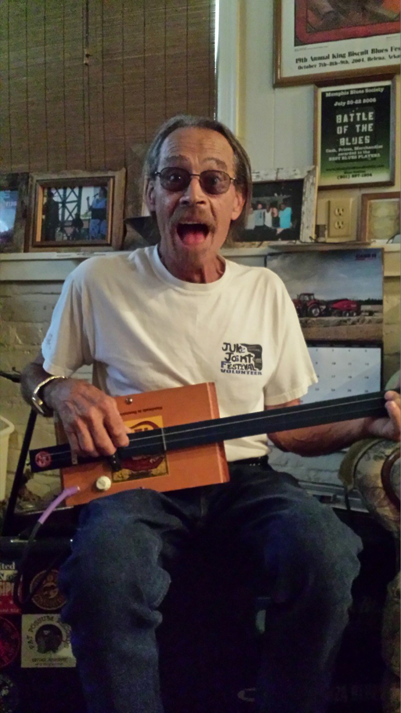 Blue Mike strumming a tune on his cigar-box guitar