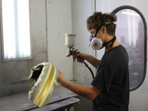 Brandon Frye demonstrates spraying technique in the paint room.