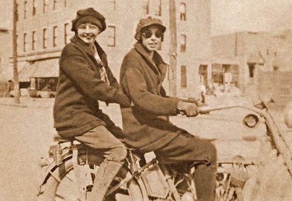 Ca. 1914: Effie, wearing goggles and riding gloves, tooling around Brooklyn on her two-cylinder machine, with a beaming female passenger. Effie earned a reputation as a speed demon.