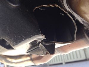 The gaping hole in the FJ-09's oil pan after the drain plug got caught on a curb.