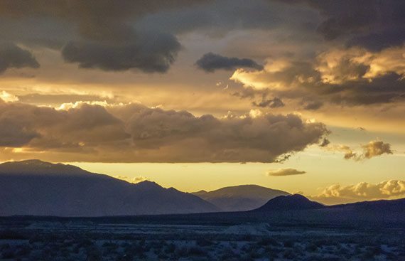 Sun, clouds and mountains mingle for a magnificent sunset. 