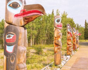 Totem carvings form a line at the Tlingit Heritage Center in Teslin.