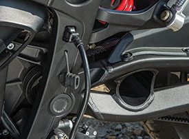 The Zero’s power cord plugs into a port in the frame, and can be coiled up and stored in the swingarm (black hole at right).