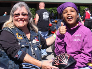 Brain tumor survivor TaMyah (right) gives the event a thumbs up. (Photo: Ride For Kids)