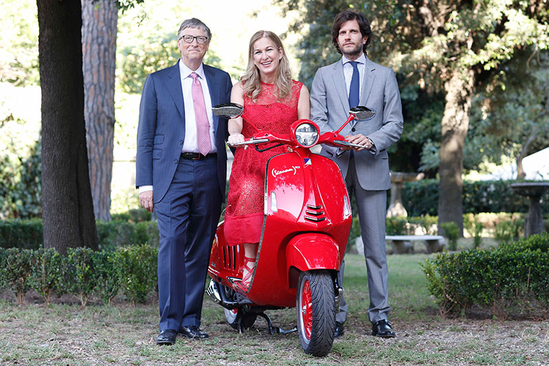 Posing with the Vespa (RED), left to right: Bill Gates, Chairman, Bill & Melinda Gates Foundation; Deborah Dugan, CEO, (RED); Michele Colaninno, CEO and Managing Director, Immsi, and Board Member of The Piaggio Group.