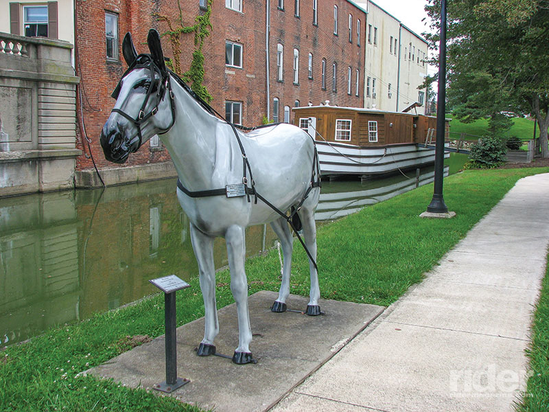 Replica of the Belle of St. Mary’s canal boat tied to a model horse alongside the canal at St. Mary’s, Ohio.