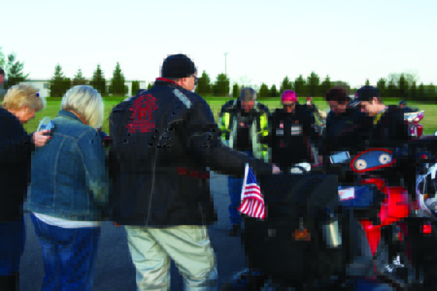 Family and friends gathered around to bless Faith and her bike for the journey ahead