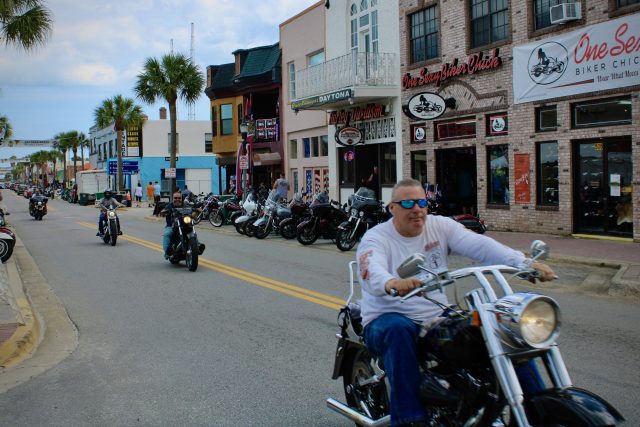 Bikers on v-twin motorcycles cruise Main Street at Daytona Beach Bike Week 2020.
