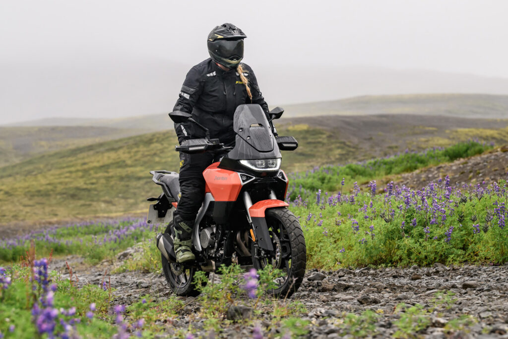 2027 Norton Atlas riding on a wet gravel road