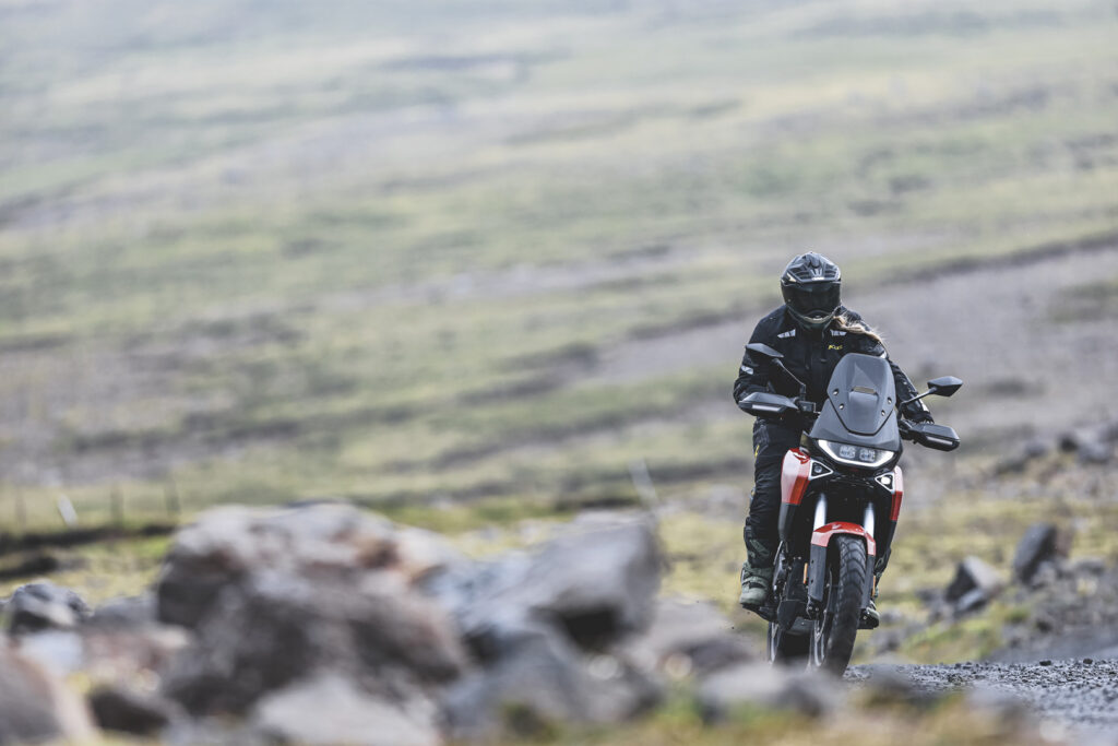 2027 Norton Atlas riding on a wet gravel road
