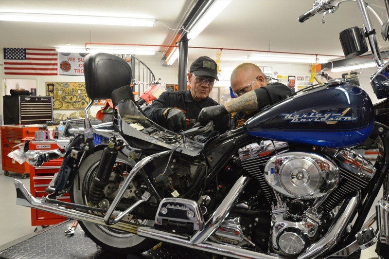 No rest for the wicked, as Kelly works on a customer's scoot during Biker Palooza
